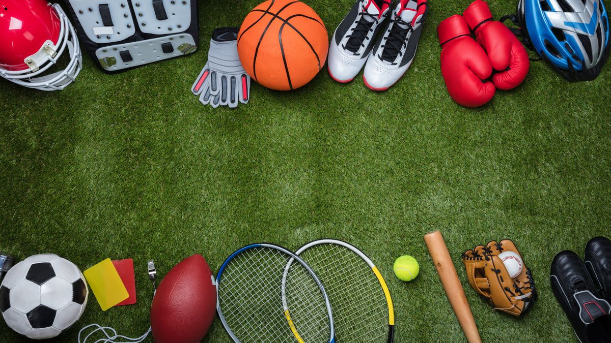 High,Angle,View,Of,Various,Sport,Equipments,On,Green,Grass
