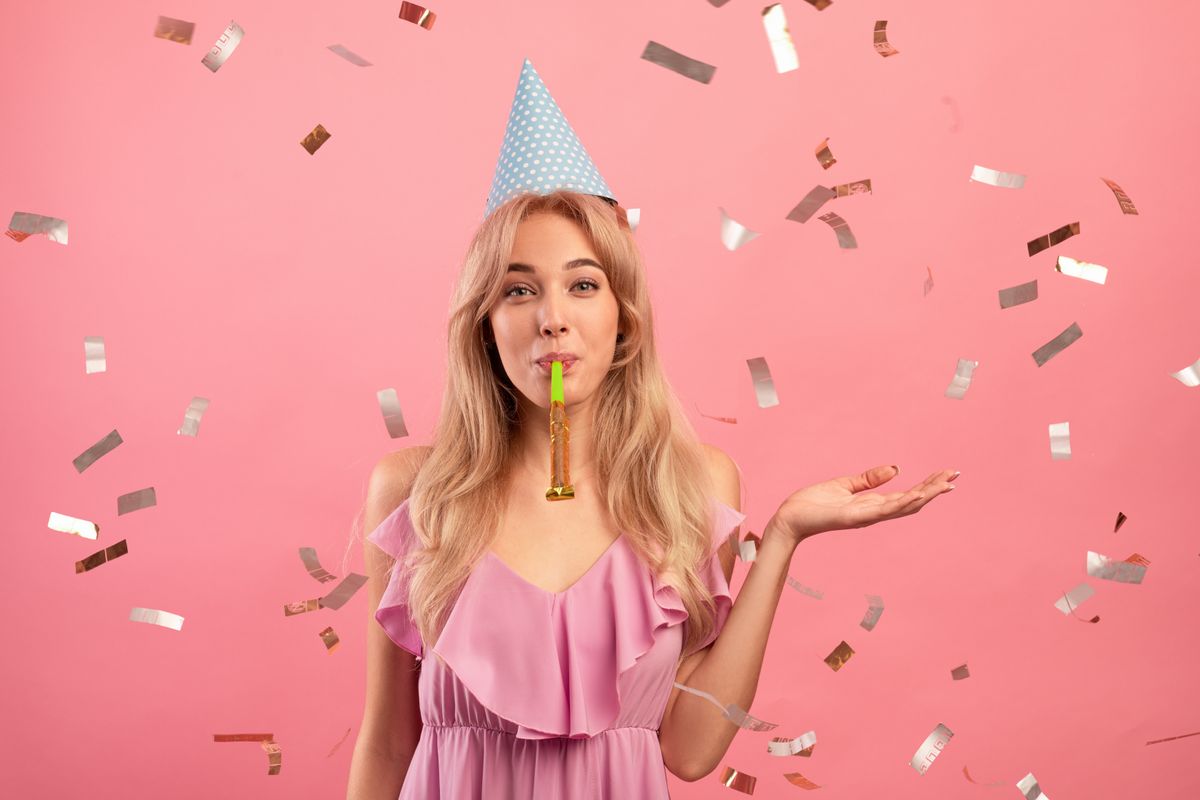 Gorgeous,Young,Woman,In,Birthday,Cap,Blowing,Party,Horn,On