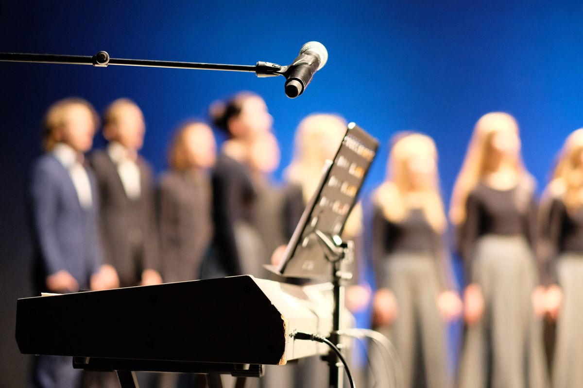 Microphone,And,Music,Stand,In,Front,Of,Electric,Pianos,On