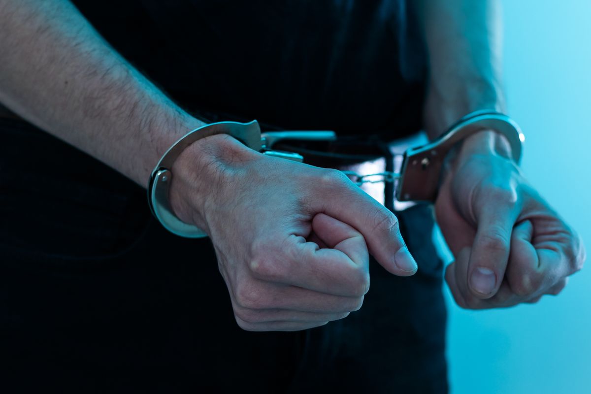 Male,Hands,In,Handcuffs,Black,Background