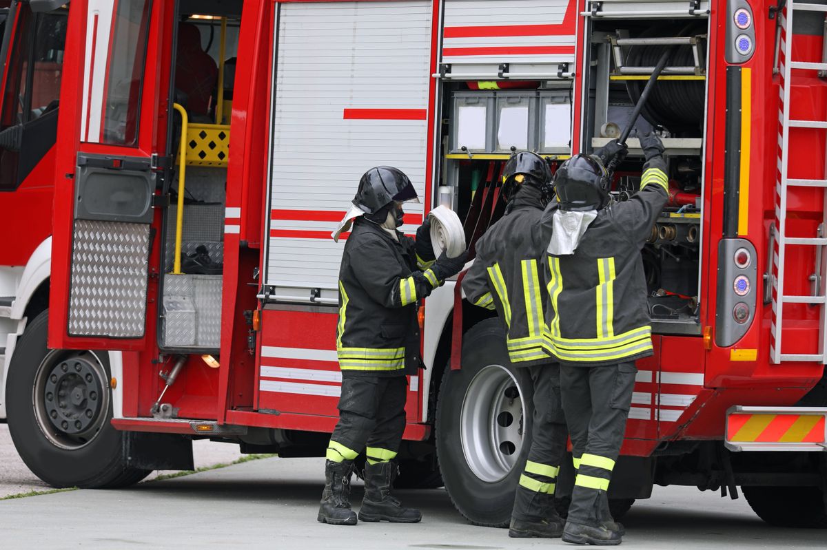 Group,Of,Firefighters,In,Action,With,The,Fire,Truck,During