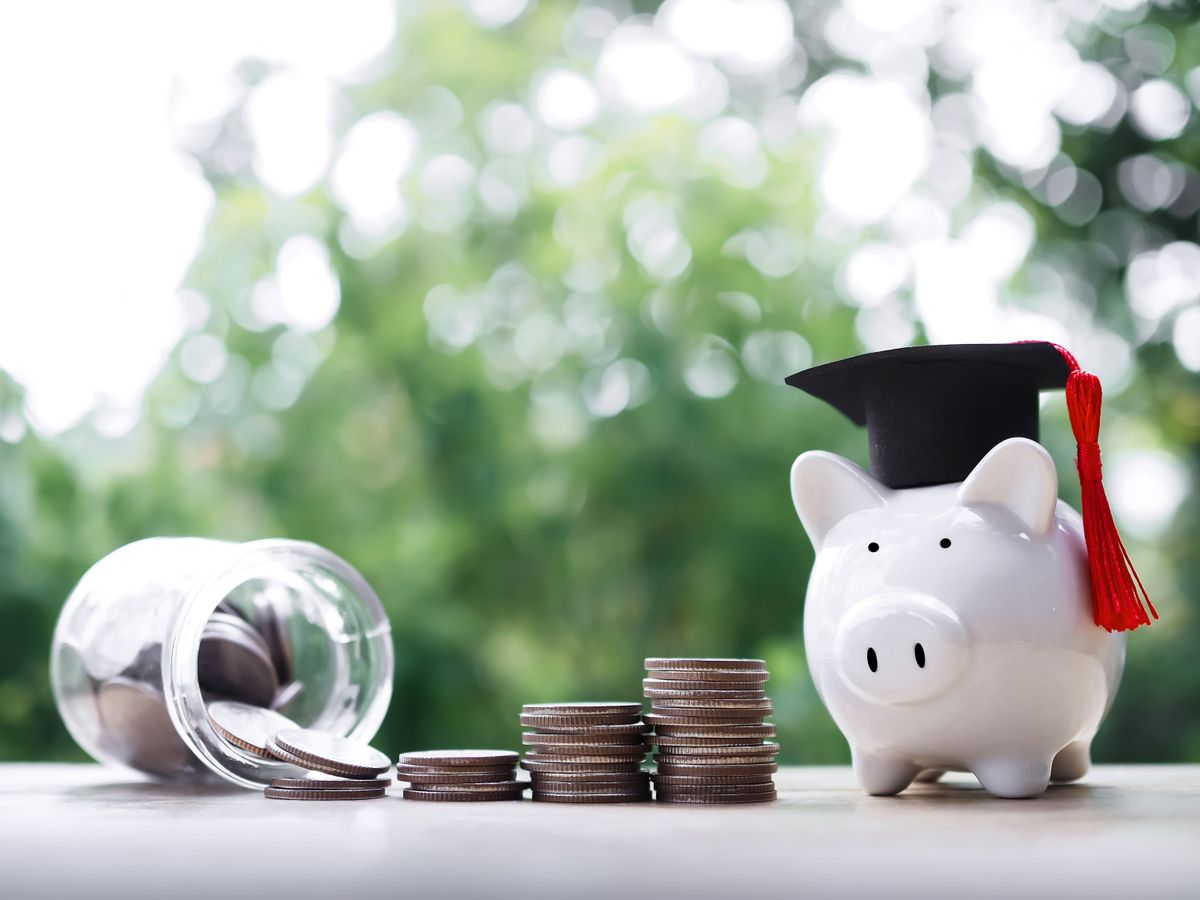 Piggy,Bank,With,Graduation,Hat,,Glass,Bottle,And,Stack,Of