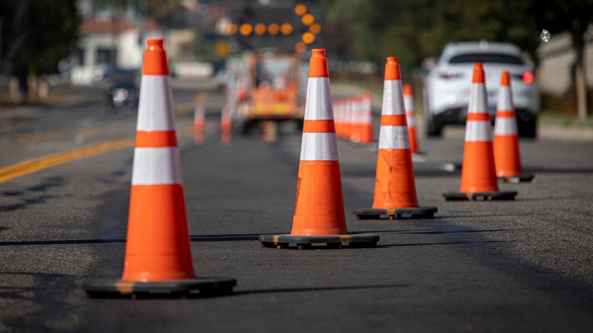 Traffic,Cones,On,Road,With,Electronic,Arrow,Pointing,To,The