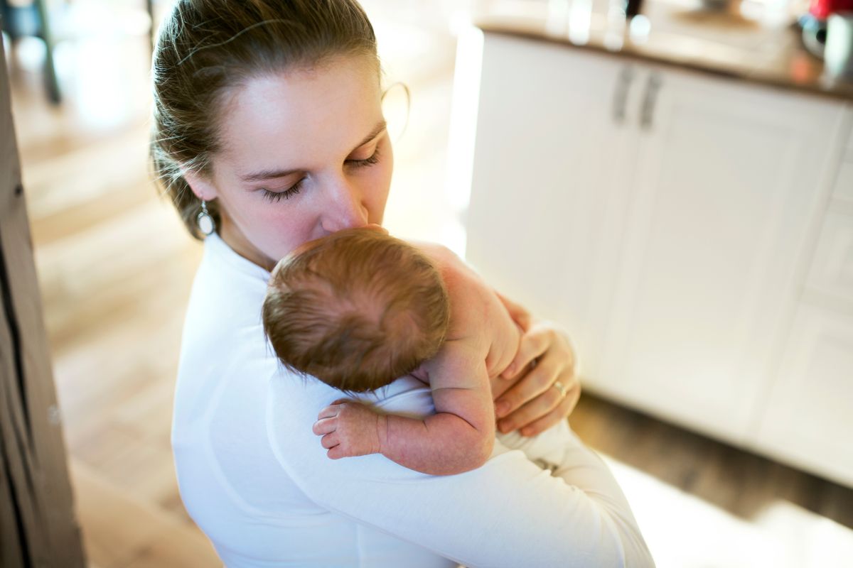 Mom,Holding,Newborn,Baby,,Looking,At,Infant,Lovingly.,Unconditional,Paternal