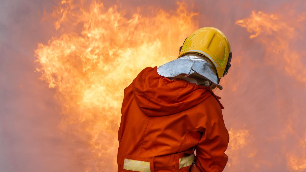 Firefighter,Man,Stop,Burning,Flame,Of,Building.